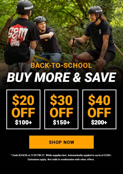 Promotional banner for back-to-school cycling deals with three riders on bicycles outdoors on a wooded path. Large text reads 'BACK TO SCHOOL BUY MORE & SAVE' with discount boxes '$20 OFF $100+', '$30 OFF $150+', '$40 OFF $200+', and a yellow 'SHOP NOW' button.